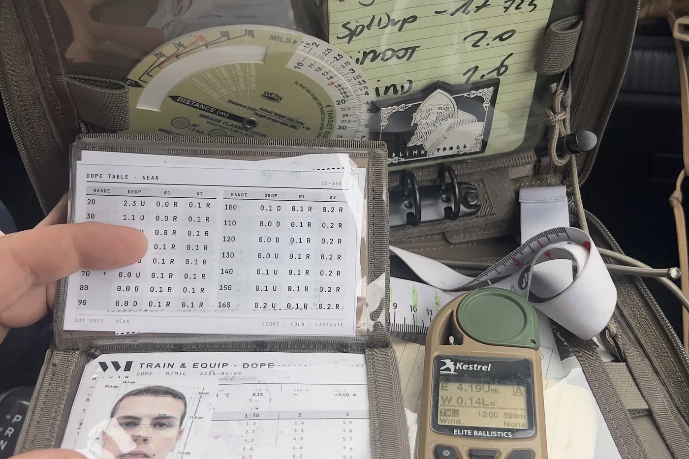 Admin pouch with a Kestrel ballistic meter, laminated DOPE cards and the mil-ranging disc as the backup